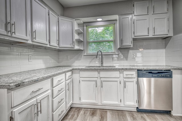 1112 Leyenda Dr, Mesquite, TX 75149 - kitchen with stainless steel dishwasher, decorative backsplash, light wood-style floors, and light stone countertops