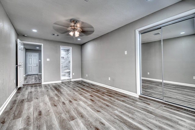 1112 Leyenda Dr, Mesquite, TX 75149 - unfurnished living room with ceiling fan, wood finished floors, a textured ceiling, and a textured wall