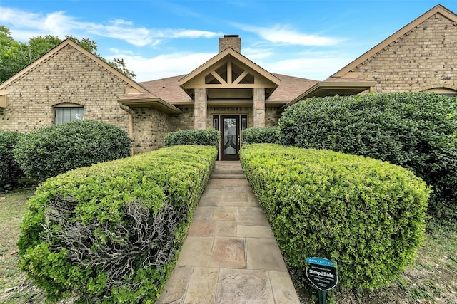2425 Northgate Dr W, Irving, TX 75062 - view of front of property featuring a chimney, brick siding, and a shingled roof