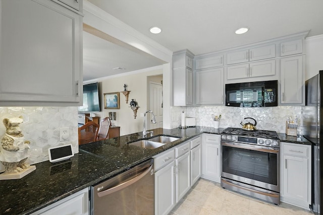 7972 Tatum Dr, Frisco, TX 75036 - kitchen featuring stainless steel appliances, dark stone countertops, a peninsula, tasteful backsplash, and ornamental molding