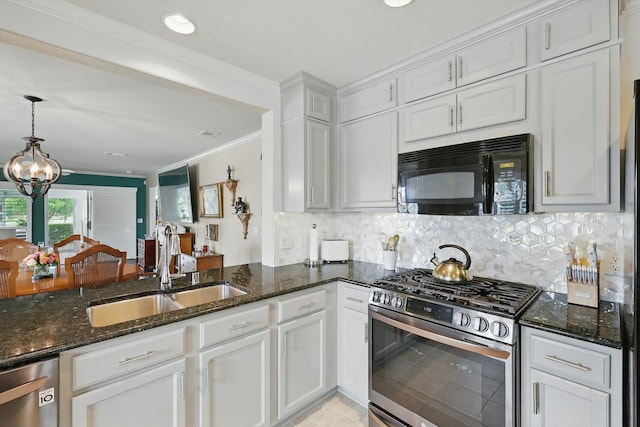 7972 Tatum Dr, Frisco, TX 75036 - kitchen featuring stainless steel appliances, dark stone countertops, white cabinets, ornamental molding, and recessed lighting