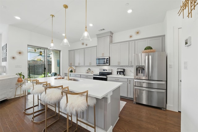 1078 Maverick Dr, Allen, TX 75013 - kitchen featuring stainless steel appliances, backsplash, dark wood finished floors, light countertops, and a breakfast bar