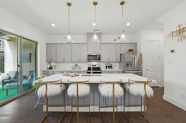 1078 Maverick Dr, Allen, TX 75013 - kitchen featuring stainless steel appliances, decorative backsplash, dark wood-style floors, light countertops, and a center island with sink