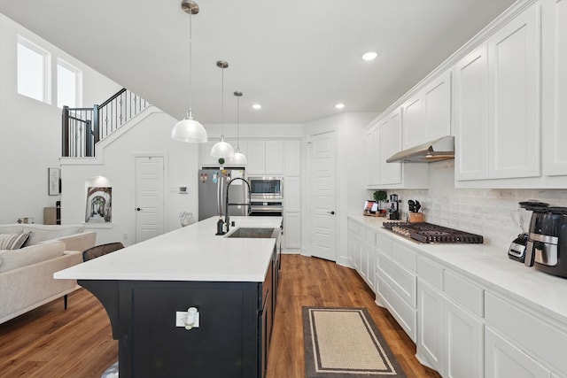 1736 Bonsmara Dr, Northlake, TX 76247 - kitchen featuring appliances with stainless steel finishes, under cabinet range hood, tasteful backsplash, white cabinetry, and recessed lighting