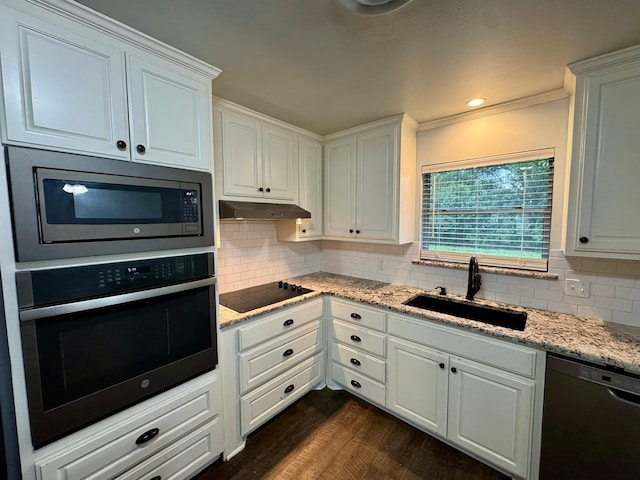 701 N Joyce St, Waco, TX 76705 - kitchen featuring stainless steel appliances, dark wood-style flooring, backsplash, white cabinetry, and ornamental molding