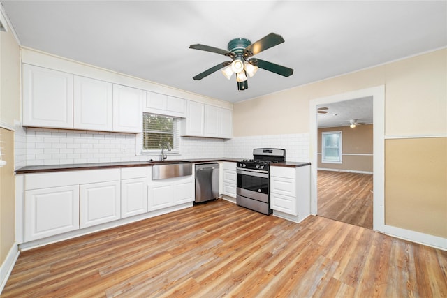 701 S Austin St, De Leon, TX 76444 - kitchen featuring appliances with stainless steel finishes, dark countertops, ceiling fan, light wood-style floors, and ornamental molding
