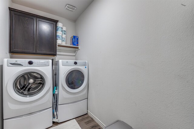 604 Grand Falls Ln, Mckinney, TX 75071 - laundry room featuring washing machine and dryer, cabinet space, and wood finished floors