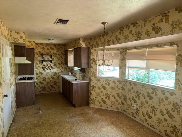 1815 Redwood St, Arlington, TX 76014 - kitchen with wallpapered walls, light countertops, dark brown cabinetry, under cabinet range hood, and light colored carpet