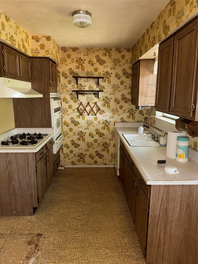1815 Redwood St, Arlington, TX 76014 - kitchen with under cabinet range hood, wallpapered walls, white appliances, light countertops, and a warming drawer