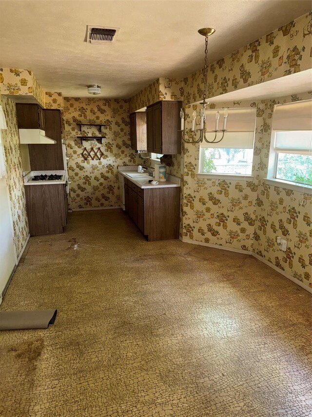 1815 Redwood St, Arlington, TX 76014 - kitchen with wallpapered walls, under cabinet range hood, carpet floors, and light countertops