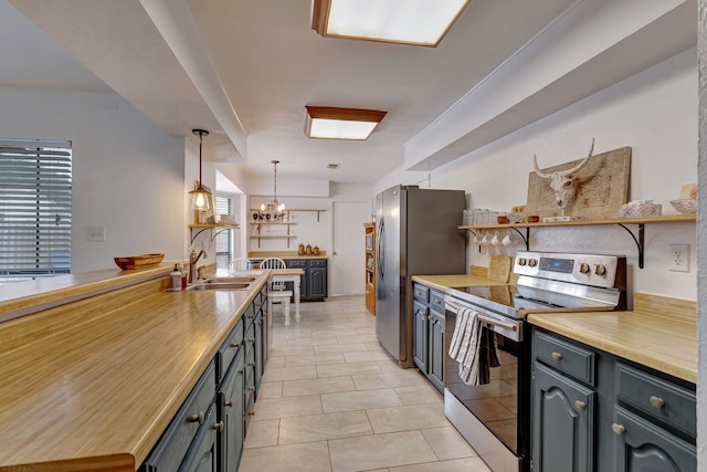 3909 Commonwealth Dr, Flower Mound, TX 75028 - kitchen featuring stainless steel appliances, open shelves, a chandelier, light tile patterned floors, and hanging light fixtures