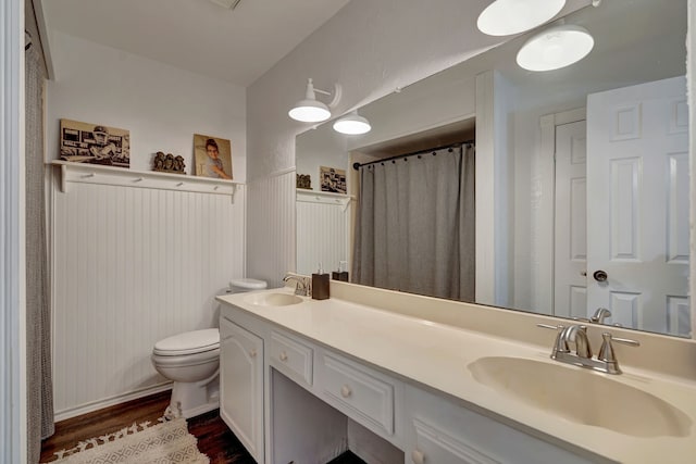 3909 Commonwealth Dr, Flower Mound, TX 75028 - bathroom with wood finished floors, double vanity, wainscoting, and a shower with curtain