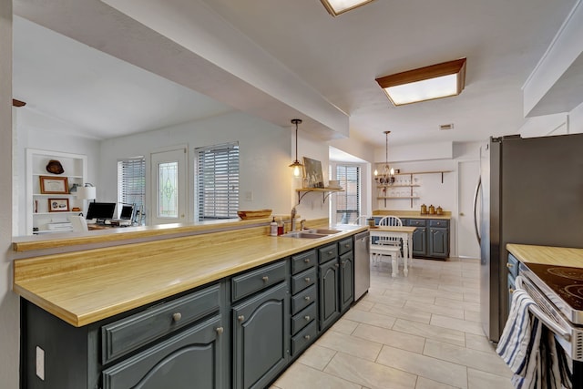 3909 Commonwealth Dr, Flower Mound, TX 75028 - kitchen featuring plenty of natural light, appliances with stainless steel finishes, light tile patterned floors, a chandelier, and lofted ceiling