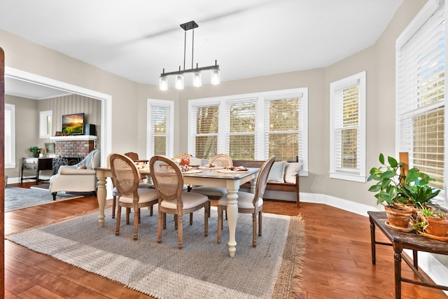 1056 Park Dr, Hillsboro, TX 76645 - dining room with wood finished floors, a brick fireplace, and plenty of natural light