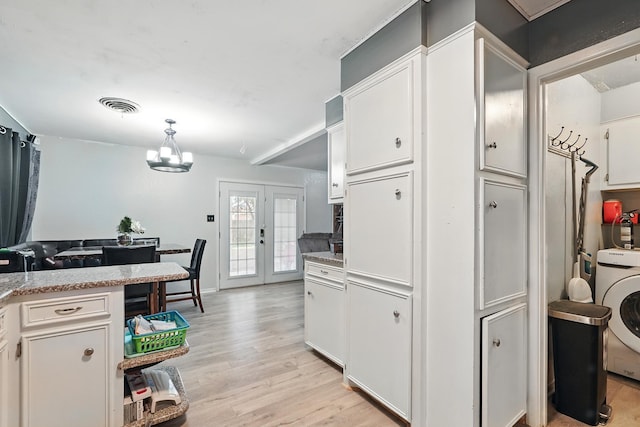 3102 Primrose Dr, Abilene, TX 79606 - kitchen featuring washer / dryer, light wood-style floors, french doors, white cabinetry, and a chandelier
