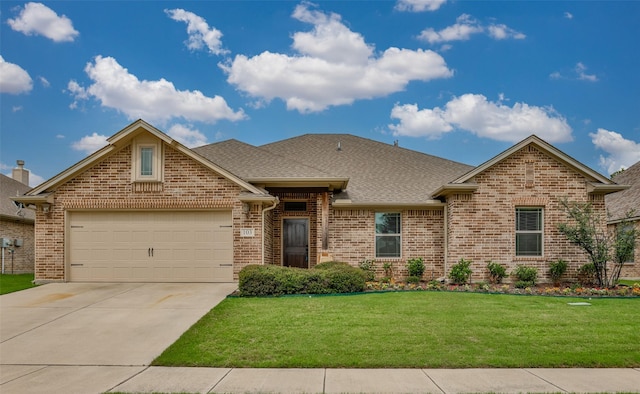 103 Loving Trl, Justin, TX 76247 - view of front facade with brick siding, concrete driveway, an attached garage, a front lawn, and roof with shingles