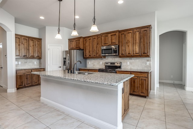103 Loving Trl, Justin, TX 76247 - kitchen with appliances with stainless steel finishes, arched walkways, light tile patterned floors, backsplash, and recessed lighting