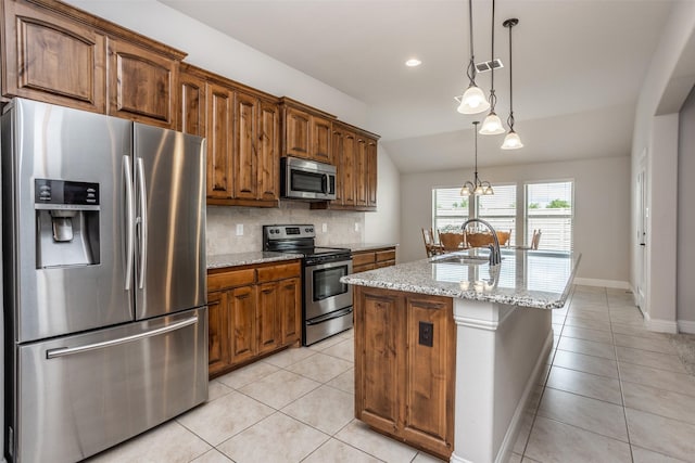 103 Loving Trl, Justin, TX 76247 - kitchen featuring appliances with stainless steel finishes, lofted ceiling, light tile patterned floors, backsplash, and an island with sink