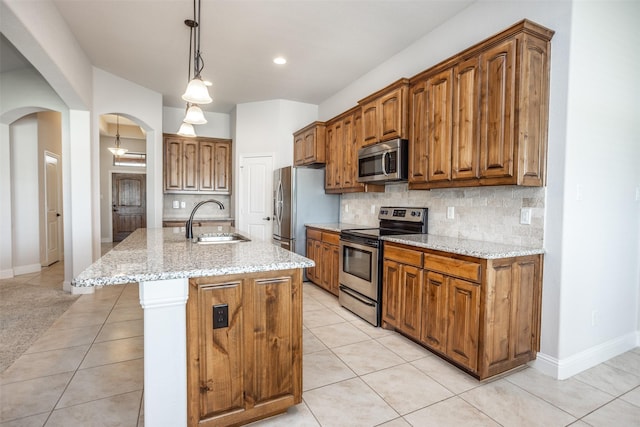 103 Loving Trl, Justin, TX 76247 - kitchen featuring stainless steel appliances, backsplash, arched walkways, light tile patterned floors, and recessed lighting