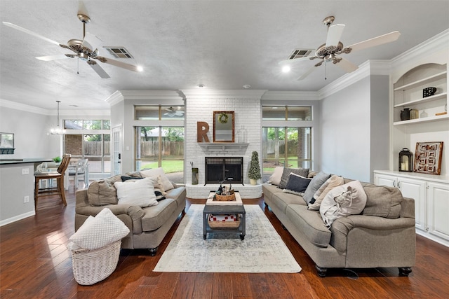 9604 Oak Springs Dr, Woodway, TX 76712 - living room with ceiling fan, dark wood-style flooring, a brick fireplace, crown molding, and recessed lighting