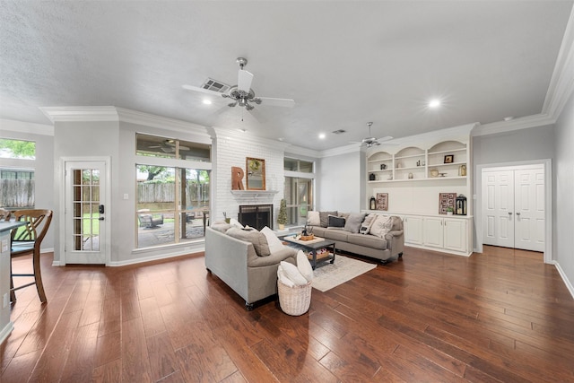 9604 Oak Springs Dr, Woodway, TX 76712 - living area with a ceiling fan, dark wood-style flooring, a large fireplace, ornamental molding, and recessed lighting