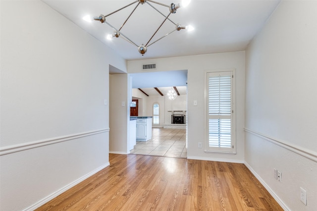 308 Woodhurst Pl, Coppell, TX 75019 - unfurnished dining area with a chandelier, light wood-type flooring, and a fireplace
