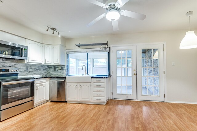 308 Woodhurst Pl, Coppell, TX 75019 - kitchen with appliances with stainless steel finishes, french doors, white cabinetry, and light wood-type flooring