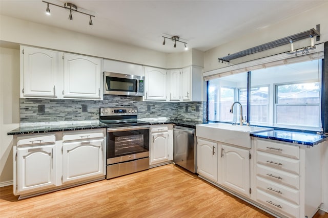 308 Woodhurst Pl, Coppell, TX 75019 - kitchen featuring appliances with stainless steel finishes, dark countertops, track lighting, and white cabinetry