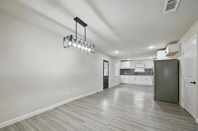 8620 Greenmound Ave, Dallas, TX 75227 - kitchen featuring freestanding refrigerator, tasteful backsplash, light wood-style floors, recessed lighting, and white cabinetry