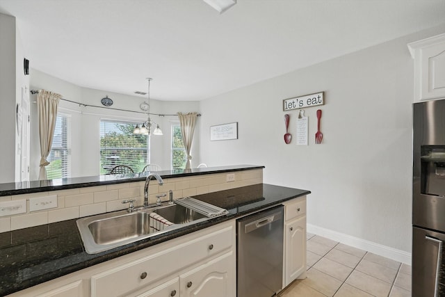 13272 Blue Jean Dr, Fort Worth, TX 76052 - kitchen with appliances with stainless steel finishes, light tile patterned flooring, hanging light fixtures, white cabinetry, and dark stone counters
