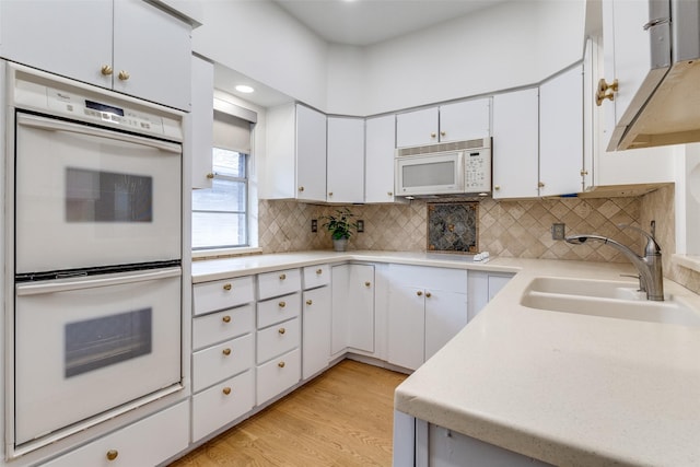 6328 Bandera Ave Unit C, Dallas, TX 75225 - kitchen with white appliances, light countertops, white cabinetry, backsplash, and ventilation hood