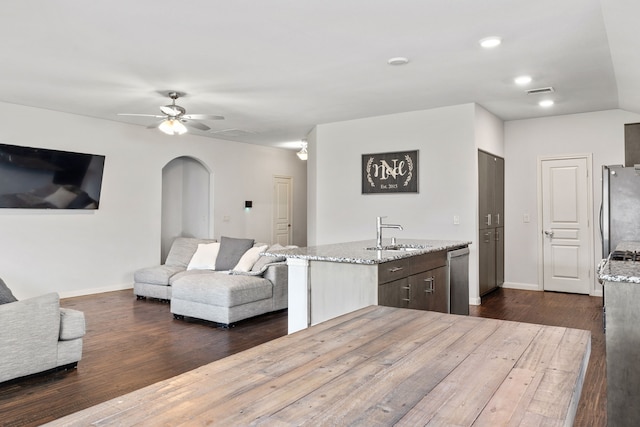 1108 Sheldon Dr, Anna, TX 75409 - kitchen featuring appliances with stainless steel finishes, open floor plan, ceiling fan, light stone countertops, and dark wood-type flooring