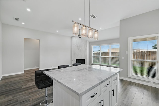 2528 Forestwood Dr, Flower Mound, TX 75028 - kitchen featuring dark wood-style floors, a center island, light stone countertops, white cabinets, and recessed lighting