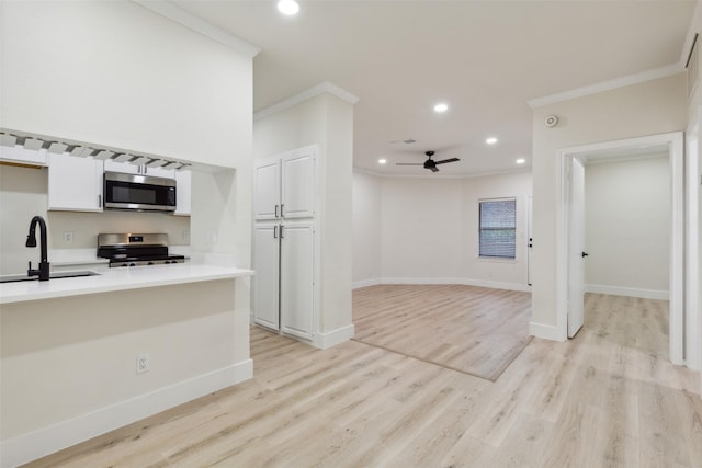 7340 Skillman St Unit 107, Dallas, TX 75231 - kitchen with appliances with stainless steel finishes, crown molding, a ceiling fan, white cabinetry, and recessed lighting