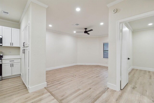 7340 Skillman St Unit 107, Dallas, TX 75231 - kitchen featuring appliances with stainless steel finishes, light wood finished floors, light countertops, white cabinetry, and ornamental molding