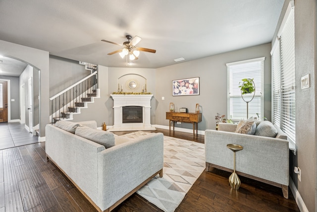1017 Appalachian Ln, Savannah, TX 76227 - living room featuring arched walkways, ceiling fan, dark wood-style floors, stairs, and a glass covered fireplace