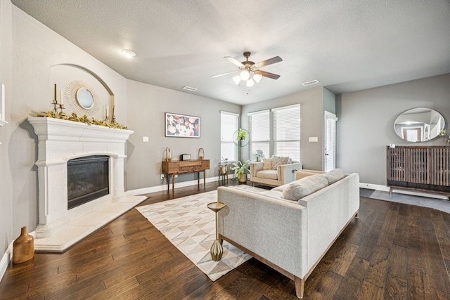 1017 Appalachian Ln, Savannah, TX 76227 - living room featuring a ceiling fan, wood-type flooring, a glass covered fireplace, and a textured ceiling