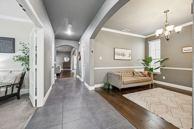 1017 Appalachian Ln, Savannah, TX 76227 - hall featuring arched walkways, a chandelier, tile patterned flooring, and crown molding