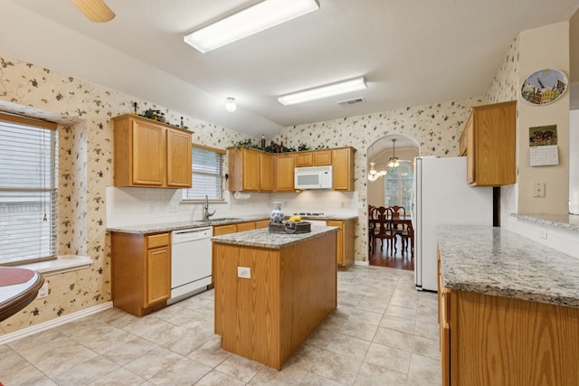 495 Bending Oaks Trl, Rockwall, TX 75087 - kitchen with white appliances, wallpapered walls, vaulted ceiling, a center island, and plenty of natural light