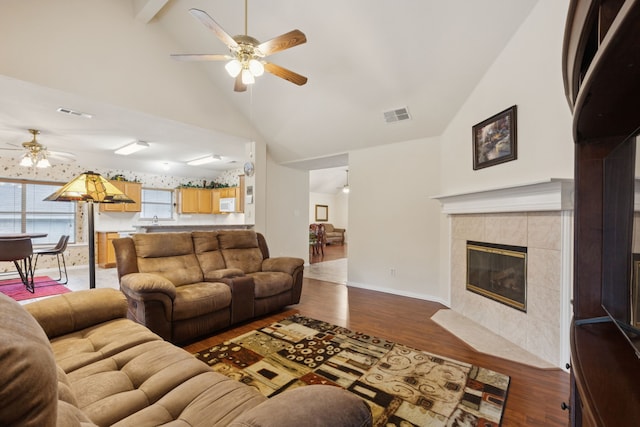 495 Bending Oaks Trl, Rockwall, TX 75087 - living area featuring a ceiling fan, vaulted ceiling, dark wood-type flooring, and a tiled fireplace