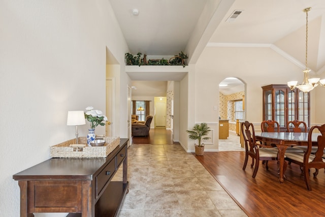 495 Bending Oaks Trl, Rockwall, TX 75087 - dining area with arched walkways, a chandelier, healthy amount of natural light, lofted ceiling, and light wood-style flooring