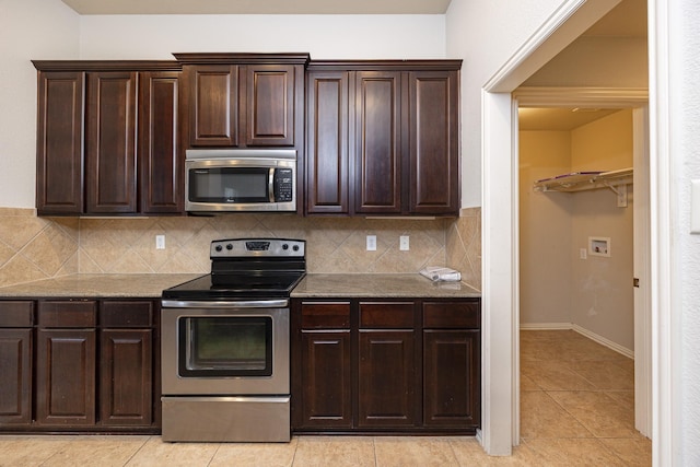 2111 Rains County Rd, Forney, TX 75126 - kitchen featuring appliances with stainless steel finishes, tasteful backsplash, light tile patterned floors, dark brown cabinetry, and light stone counters