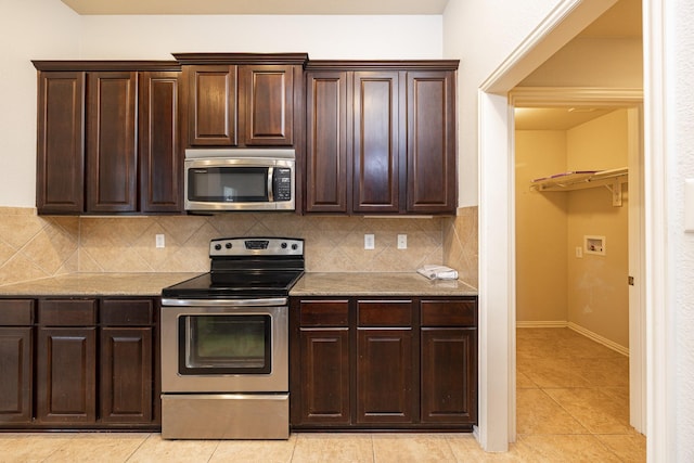 2111 Rains County Rd, Forney, TX 75126 - kitchen with stainless steel appliances, light tile patterned flooring, tasteful backsplash, dark brown cabinetry, and light stone counters
