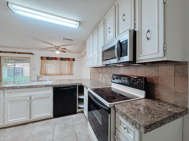 220 Hampton Ave, Corsicana, TX 75110 - kitchen with black dishwasher, white range with electric stovetop, stainless steel microwave, and white cabinets