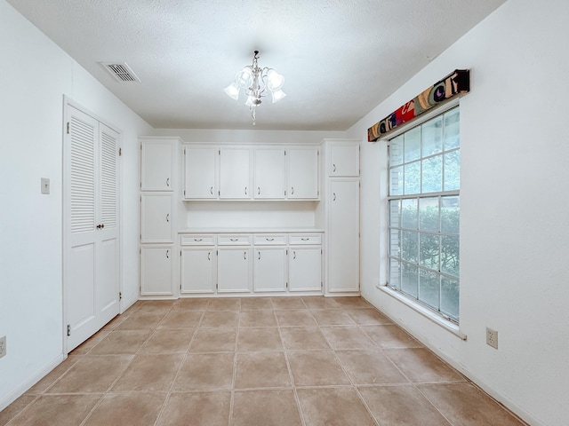 220 Hampton Ave, Corsicana, TX 75110 - unfurnished dining area featuring a chandelier and light tile patterned flooring