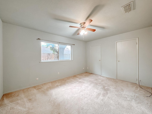 220 Hampton Ave, Corsicana, TX 75110 - unfurnished bedroom featuring carpet, a ceiling fan, and multiple closets