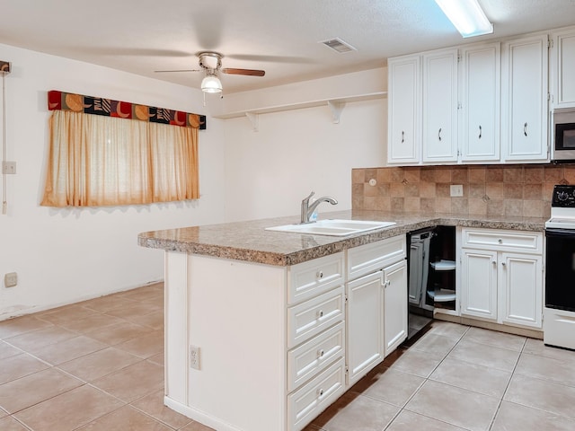 220 Hampton Ave, Corsicana, TX 75110 - kitchen featuring white range with electric stovetop, a peninsula, light tile patterned flooring, and white cabinets