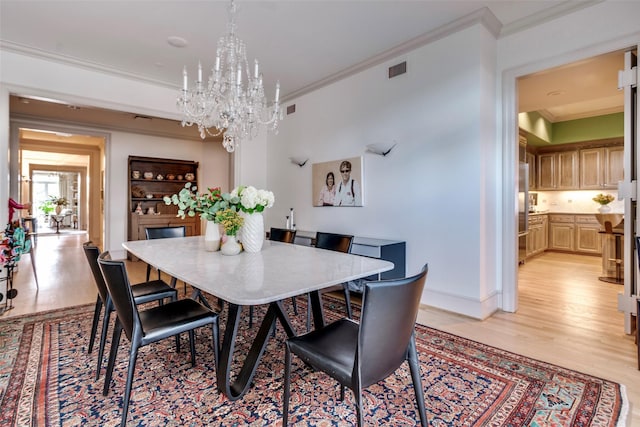 3505 Turtle Creek Blvd Unit 2A, Dallas, TX 75219 - dining room featuring a chandelier, light wood-style floors, and ornamental molding