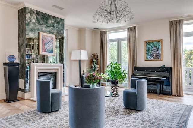 3505 Turtle Creek Blvd Unit 2A, Dallas, TX 75219 - sitting room with crown molding, plenty of natural light, a chandelier, and a glass covered fireplace