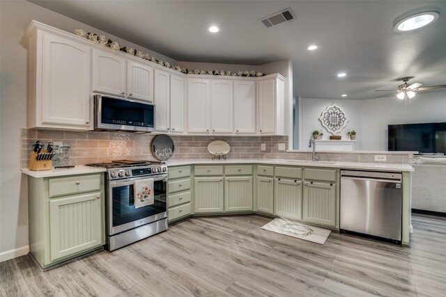 1237 Bay Line Dr, Rockwall, TX 75087 - kitchen with stainless steel appliances, green cabinetry, open floor plan, a peninsula, and recessed lighting